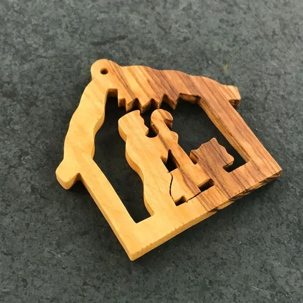 Produktbild von Alt-Text: Baumanhänger aus Olivenholz mit Maßen von 5,5 bis 6,0 cm und einer geölten Oberfläche.