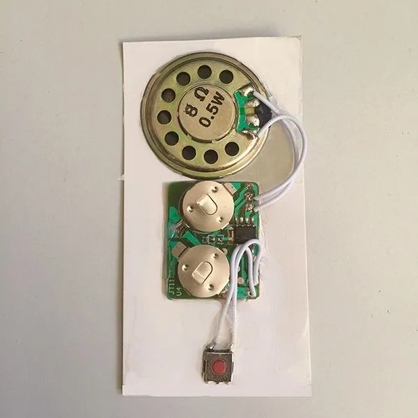 Produktbild von Kleines, flaches Soundmodul mit 26 mm Lautsprecherdurchmesser, integriertem Mini-Drucktaster und platzsparender Spezial-Platine für den Einsatz mit nur 2 Knopfzellen.
