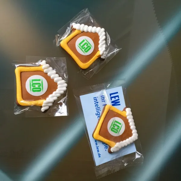 Produktbild von Handgefertigte Lebkuchen-Häuschen mit individuellem Logodruck und Werbekarte, liebevoll verziert und duften wunderbar.